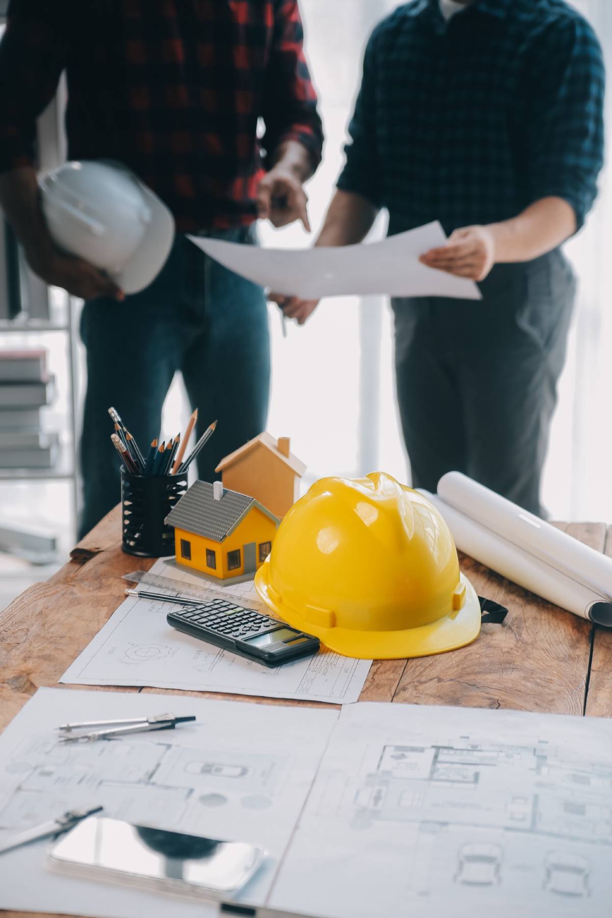 Close up of civil male engineer asian working on blueprint architectural project at construction site at desk in office.